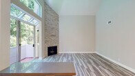 Located at 10125 Palms Blvd in the Palms neighborhood of Los Angeles, this single-level residence combines modern updates with architectural character. The living area immediately impresses with soaring vaulted ceilings that enhance the sense of openness, complemented by a dramatic floor-to-ceiling stacked stone fireplace serving as a striking focal point. Large windows and a glass-paned door invite abundant natural light and views of lush greenery, while light-toned hardwood-style flooring runs throughout the main living spaces.

The kitchen is thoughtfully appointed with white shaker cabinetry, grey countertops, a deep teal subway tile backsplash, and a full suite of stainless steel appliances including a gas range, refrigerator, dishwasher, and microwave. Plantation shutters on the kitchen window add a classic touch. A sputnik-style chandelier illuminates the dining area, adding a contemporary flair.

The hallway connects the main living areas to the private quarters, where bedrooms feature plush carpeting, crown molding, ceiling fans, and plantation-shuttered windows offering natural light and privacy. The bathroom showcases white cabinetry with grey countertops and clean, modern finishes. A walk-in closet provides generous storage. This well-maintained residence offers a cohesive blend of comfort and style in a prime Los Angeles location.