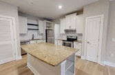 This contemporary 970 square foot apartment in Suwanee, GA offers a blend of comfort and style. The space features two bedrooms, including a spacious 160 square foot primary bedroom, and two full bathrooms. The modern kitchen is a highlight, boasting white cabinetry, granite countertops, stainless steel appliances, and a central island with additional storage.

Throughout the apartment, you'll find a neutral color palette that creates a bright, airy atmosphere. The bedrooms are carpeted for comfort, while the living areas and kitchen feature sleek hardwood flooring. Large windows in each room allow for plenty of natural light, and modern ceiling fans provide additional comfort and air circulation.

The bathrooms continue the modern aesthetic with granite vanity tops, white cabinetry, and light wood-look flooring. An in-unit laundry room adds convenience to daily living. The overall layout is well-designed, with an open concept living and kitchen area that's perfect for entertaining or relaxing.

Storage is ample throughout, with multiple closets and built-in shelving. The apartment's single-story layout ensures easy accessibility. Located at 1035 Scales Rd, this apartment offers a perfect blend of modern amenities and comfortable living space in a desirable Suwanee location.