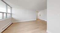 Located at 25 Leith Hill Road in Toronto's north end, this well-appointed 3-bedroom, 2-bathroom unit offers a clean, modern aesthetic throughout. Light-toned hardwood flooring flows seamlessly across the entire unit, complementing the crisp white walls and creating a bright, cohesive atmosphere.

The open-concept living area is generously proportioned, with large windows that allow abundant natural light and offer views of the surrounding Toronto skyline. Baseboard heating runs along the perimeter of the main rooms, ensuring year-round comfort. The kitchen is outfitted with high-gloss white cabinetry, matte black hardware, white quartz countertops, a subway tile backsplash, and stainless steel appliances including a refrigerator, range, and dishwasher.

Three well-sized bedrooms provide comfortable accommodation, with the primary bedroom offering ample space. At least one bedroom features a sliding-door closet. Both bathrooms are finished in a modern style, with white vanities, quartz countertops, undermount sinks, matte black fixtures, and large mirrors. The overall design is clean and minimal, making the unit feel bright and functional throughout.
