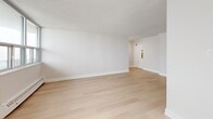 Located at 25 Leith Hill Road in Toronto's north end, this well-appointed 3-bedroom, 2-bathroom unit offers a clean, modern aesthetic throughout. Light-toned hardwood flooring flows seamlessly across the entire unit, complementing the crisp white walls and creating a bright, cohesive atmosphere.

The open-concept living area is generously proportioned, with large windows that allow abundant natural light and offer views of the surrounding Toronto skyline. Baseboard heating runs along the perimeter of the main rooms, ensuring year-round comfort. The kitchen is outfitted with high-gloss white cabinetry, matte black hardware, white quartz countertops, a subway tile backsplash, and stainless steel appliances including a refrigerator, range, and dishwasher.

Three well-sized bedrooms provide comfortable accommodation, with the primary bedroom offering ample space. At least one bedroom features a sliding-door closet. Both bathrooms are finished in a modern style, with white vanities, quartz countertops, undermount sinks, matte black fixtures, and large mirrors. The overall design is clean and minimal, making the unit feel bright and functional throughout.