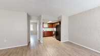 Located at 3809 W Iowa Ave in Tampa, Florida, this single-story home offers a practical and functional layout with a clean, neutral aesthetic throughout. Light wood-style flooring flows consistently across the living areas and bedrooms, creating a cohesive and easy-to-maintain interior.

The living area welcomes natural light through multiple windows fitted with blinds, and features a textured accent wall alongside a wall-mounted air conditioning unit. An adjacent entryway area provides a defined front entrance with its own window, adding to the brightness of the space.

The kitchen is well-appointed with warm, rich-toned wood cabinetry, a classic white subway tile backsplash, light stone-look countertops, and a stainless steel electric range. A black refrigerator and a flush-mounted skylight ceiling fixture round out the functional and attractive kitchen design.

The bedrooms are generously proportioned with neutral-toned walls, textured ceilings, and ample natural light from windows. One bedroom includes a sliding door closet, while another connects directly to the hallway for easy access. The bathroom features large-format warm-toned tile surrounding a full tub-shower combination, complemented by wood-look flooring. Overall, the home presents a tidy, move-in ready environment suited for comfortable everyday living.