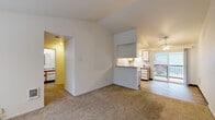 Located at 8010 SW Avery St in Tualatin, Oregon, this two-bedroom, one-bathroom unit offers a well-organized single-floor layout designed for comfortable everyday living. The open living room greets you with soft carpeting, vaulted ceilings, and a large window that fills the space with natural light and views of the surrounding greenery. A ceiling fan overhead adds to the airy feel of the room.

The kitchen and dining area are combined into one functional space, featuring a galley-style kitchen with white cabinetry accented by wood trim, ample counter space, a full suite of white appliances including a refrigerator, electric range, and dishwasher, and durable tile-style flooring. A pass-through bar connects the kitchen to the adjacent dining and living areas, making the layout feel open and connected. Sliding glass doors lead to a private balcony.

Both bedrooms are carpeted and receive natural light through well-positioned windows. The primary bedroom includes a mirrored sliding closet and a direct hallway connection to the bathroom. Additional closets throughout provide generous storage. The full bathroom features a combined tub and shower. A dedicated laundry area and hallway complete the layout, making this a practical and efficiently designed home.