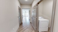 This contemporary apartment in McKinney, Texas, offers 1180 square feet of thoughtfully designed living space. The single-story layout comprises three bedrooms, including a spacious 190 square foot primary bedroom, and two full bathrooms. The heart of the home is an open-concept kitchen and living area, featuring sleek cabinetry, granite countertops, and stainless steel appliances. Large windows throughout provide ample natural light, while modern ceiling fans ensure comfort. The flooring is a harmonious mix of warm wood-look vinyl in main living areas and plush carpeting in bedrooms. Bathrooms boast clean lines with white fixtures and subway tile accents. Storage is abundant, with multiple closets and a dedicated laundry area. Crown molding adds a touch of elegance, while neutral paint colors create a versatile backdrop for any decor style. This well-appointed apartment combines functionality with contemporary aesthetics, offering a turnkey living solution in a desirable location.
