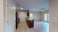 This single-floor, two-bedroom residence in Nashville, Tennessee offers a well-designed open-concept layout that connects the kitchen and living areas seamlessly. The kitchen is a standout feature, equipped with rich dark-espresso cabinetry, granite countertops with striking veining, black appliances including a full-size refrigerator and dishwasher, and a peninsula that extends into the living space—providing additional prep space and casual seating. Wood-style plank flooring runs throughout the main living areas, lending a cohesive, contemporary feel.

The living area is generously proportioned, with a ceiling fan overhead and natural light filtering in through slatted blinds. Both bedrooms are comfortably sized, each featuring wood-style flooring, ceiling fans with lighting, and windows that invite natural light. The bedrooms offer access to well-appointed bathrooms, each featuring granite-topped dark vanities, tile flooring, large mirrors, and a tub-shower combination. The primary bathroom includes additional walk-in closet space. Neutral wall tones throughout the residence create a versatile backdrop, contributing to an overall atmosphere that is clean, modern, and move-in ready.