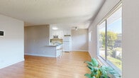 Located in Spring Valley, California, this single-floor, 2-bedroom, 2-bathroom home offers a practical and comfortable layout filled with natural light. The open-concept living room and kitchen area serves as the heart of the home, featuring warm light wood flooring that extends throughout. Large sliding glass doors and windows invite abundant natural light and offer views of the surrounding greenery, enhancing the airy feel of the space. A wall-unit HVAC system provides climate control in the living area.

The kitchen is efficiently designed in a U-shaped layout with white cabinetry extending to the ceiling for ample storage, white appliances including a range, microwave, refrigerator, and a peninsula with bar seating — ideal for casual dining. Textured ceilings are present throughout the home.

Both bedrooms are bright and well-proportioned, with light wood flooring and windows overlooking the neighborhood. The primary bedroom includes a dedicated closet, offering convenient storage. The second bedroom also benefits from natural light through a large window.

The bathrooms are clean and functional. One features a tub-shower combination with a glass enclosure, a white vanity with modern brushed-nickel fixtures, and tile flooring. The home's neutral color palette and consistent finishes create a cohesive and move-in-ready living environment.