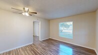 Located at 2716 E Washington St in Orlando, FL, this efficient single-floor, one-bedroom, one-bathroom home offers a well-organized layout across a compact yet functional footprint. The living room welcomes you with warm wood-look laminate flooring, neutral beige walls, a textured ceiling, and a ceiling fan with integrated lighting. Multiple windows flood the space with natural light, creating a bright and airy ambiance. A dedicated entry door with a modern smart lock adds a practical touch.

The bedroom is a comfortable retreat, featuring the same wood-look flooring, a ceiling fan, a wall-mounted mini-split unit for climate control, and a sliding-door closet. Windows overlook the surrounding greenery, enhancing the sense of openness.

The kitchen is clean and contemporary, outfitted with white shaker-style cabinetry, marble-look countertops, a hexagonal tile backsplash, a stainless steel sink, and light tile flooring. A window above the sink brings in natural light. Additional storage is provided by a pantry adjacent to the kitchen.

The bathroom features a full tub-shower combination dressed in large-format marble-look tile, paired with a white toilet for a crisp, clean finish. The home's cohesive, updated aesthetic makes it an efficient and comfortable Orlando residence.