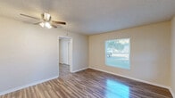 Located at 2716 E Washington St in Orlando, FL, this efficient single-floor, one-bedroom, one-bathroom home offers a well-organized layout across a compact yet functional footprint. The living room welcomes you with warm wood-look laminate flooring, neutral beige walls, a textured ceiling, and a ceiling fan with integrated lighting. Multiple windows flood the space with natural light, creating a bright and airy ambiance. A dedicated entry door with a modern smart lock adds a practical touch.

The bedroom is a comfortable retreat, featuring the same wood-look flooring, a ceiling fan, a wall-mounted mini-split unit for climate control, and a sliding-door closet. Windows overlook the surrounding greenery, enhancing the sense of openness.

The kitchen is clean and contemporary, outfitted with white shaker-style cabinetry, marble-look countertops, a hexagonal tile backsplash, a stainless steel sink, and light tile flooring. A window above the sink brings in natural light. Additional storage is provided by a pantry adjacent to the kitchen.

The bathroom features a full tub-shower combination dressed in large-format marble-look tile, paired with a white toilet for a crisp, clean finish. The home's cohesive, updated aesthetic makes it an efficient and comfortable Orlando residence.