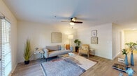 This single-floor residence offers a well-designed layout with a cohesive, modern aesthetic throughout. The living room serves as the heart of the space, featuring wood-look flooring, a ceiling fan with light fixture, and French doors that open to an outdoor view, allowing natural light to fill the room. The open-concept kitchen is equipped with stainless steel appliances, including a full-size refrigerator and gas range, complemented by white subway tile backsplash, light cabinetry, a peninsula with pendant lighting, and a skylight above that brightens the cooking area. Adjacent to the kitchen, a dedicated dining nook provides a comfortable space for casual meals. A hallway connects the living areas to the bedroom, with a reach-in closet accessible nearby. The bedroom is carpeted for comfort and includes a ceiling fan, a window with blinds that invites natural light, and a spacious closet. The full bathroom features a single-sink vanity with ample cabinet storage, a tiled tub-shower combination, and wood-look flooring. Throughout the unit, neutral walls and consistent flooring create a clean, inviting atmosphere.