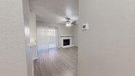 This single-story, 1-bedroom, 1-bathroom residence offers a thoughtfully designed layout that maximizes functionality and comfort. The open-concept main living area seamlessly combines the living room, dining room, and kitchen into one cohesive space. The living room is highlighted by a classic brick fireplace, a ceiling fan with light fixture, and a large sliding glass door dressed with vertical blinds that invites natural light and provides outdoor access. Light-toned laminate flooring runs throughout, complementing the neutral gray walls and white trim for a clean, modern aesthetic. The kitchen features white cabinetry, light granite-style countertops, a black electric range with overhead exhaust hood, and a window that brings in additional natural light. The bedroom is generously sized, equipped with its own ceiling fan, a large window, and access to ample closet space, including a walk-in closet with built-in shelving and hanging rods. Additional storage is provided through multiple closets and a dedicated pantry. The bathroom is finished with a full-size tub and shower combo, a toilet, and white cabinetry. A textured ceiling detail is present throughout the living areas, adding a subtle architectural touch to this well-organized and efficiently designed home.