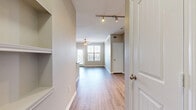 This single-story residence offers a thoughtfully designed layout across three bedrooms and two bathrooms. The entrance opens into a hallway with built-in shelving, leading to a combined kitchen and living area that serves as the heart of the home. Track lighting illuminates the open-concept space, which features wood-look flooring and a ceiling fan. A sliding glass door and large windows in the living area invite abundant natural light and provide outdoor views.

The kitchen is well-equipped with rich dark wood cabinetry, granite countertops, a glass tile backsplash, stainless steel appliances, and a central island with a sink — ideal for both cooking and casual dining.

The three bedrooms feature plush carpeting, ceiling fans, and windows with views of the surrounding area. The primary bedroom includes a walk-in closet with built-in shelving and hanging rods. The bathrooms are finished with dark wood vanities, granite countertops, and wood-look tile flooring. One bathroom features a window, adding natural light to the space.

Overall, the residence presents a cohesive, modern aesthetic with neutral tones, quality finishes, and a practical, comfortable layout.