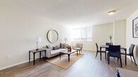 Located at 400 W Franklin Street in Richmond, Virginia, this single-floor residence offers a thoughtfully designed layout with a clean, neutral aesthetic throughout. The open living and dining area serves as the heart of the space, featuring warm hardwood-style flooring, soft cream-toned walls, and generous natural light streaming through large windows fitted with horizontal blinds. The living area provides ample room for comfortable seating arrangements, while the adjacent dining space transitions seamlessly into the kitchen via an open doorway.

The kitchen is equipped with rich walnut-toned cabinetry, a full suite of black appliances including a wall oven, dishwasher, and cooktop, along with a double sink. Tile flooring grounds this functional space, which also features generous counter and storage space.

The bedrooms are well-proportioned and bright, each benefiting from large windows that frame views of the Richmond cityscape. Hardwood-style flooring continues throughout, and closet space is available in each room. The bathroom retains a classic character with vintage octagonal tile flooring, a pedestal sink, and a tub-shower combination. Overall, the space presents a calm, livable environment in the heart of Richmond.