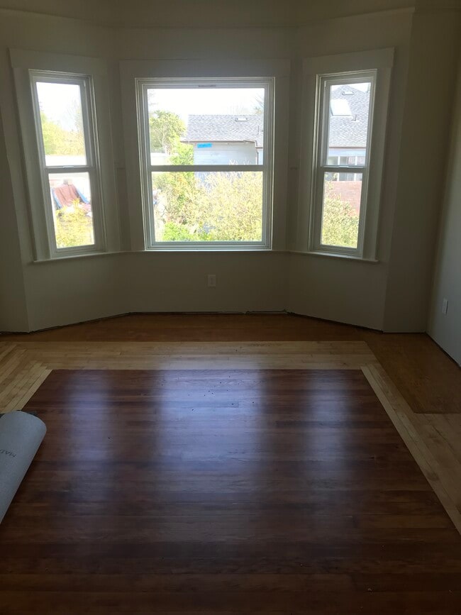 Elegant living room with hardwood floor, crown molding, high ceilings, and tons of natural light. - 314 Rigg St