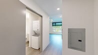Located at 3803 S Warsaw St in Seattle, WA, this thoughtfully designed two-bedroom, one-bathroom residence offers a clean, contemporary aesthetic throughout its single-story layout. Light-toned luxury vinyl plank flooring flows seamlessly through every room, complementing the crisp white walls and creating a bright, cohesive atmosphere.

The kitchen is outfitted with a full suite of stainless steel appliances, including a refrigerator, electric range, and over-the-range microwave. White flat-panel cabinetry extends to the ceiling, maximizing storage, while a white quartz countertop and stainless steel sink complete the functional design. Recessed lighting illuminates the space, which opens toward a large window framing lush, green neighborhood views.

Both bedrooms are well-proportioned and feature large windows fitted with roller shades, inviting ample natural light while maintaining privacy. Each room includes a dedicated closet with wire shelving. The primary bedroom offers an elevated sense of space with higher ceilings and a generous layout.

The bathroom is finished in a clean, minimal style with a walk-in shower and wood-look tile flooring. A standout practical feature is the stacked in-unit washer and dryer, conveniently located adjacent to the bathroom. A central hallway connects all rooms, ensuring a logical and efficient floor plan throughout.