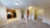 Located at 2011 Signal Drive in Johnson City, Tennessee, this single-floor, one-bedroom, one-bathroom residence offers a practical and efficient layout. The kitchen is well-equipped with warm wood cabinetry, ample counter space, black appliances including a range, dishwasher, and refrigerator, and a classic checkered tile floor that adds a timeless character to the space. The open living area features neutral-toned carpet and a notable structural column, adding an architectural detail to the room. A doorway leads to additional storage or utility space, enhancing the functionality of the layout. The bedroom is comfortably sized, finished with soft carpet underfoot and a ceiling fan with integrated lighting, providing both comfort and ventilation. The bathroom is a standout feature, showcasing a full tub and shower combination surrounded by large-format beige tiles accented by a decorative band of cobalt blue and multicolored mosaic tiles, adding a distinctive touch. Throughout the residence, neutral wall tones and consistent flooring choices create a cohesive and understated aesthetic. This property offers a straightforward, move-in-ready layout suited for those seeking a compact and manageable living space in Johnson City, TN.