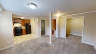 Located at 2011 Signal Drive in Johnson City, Tennessee, this single-floor, one-bedroom, one-bathroom residence offers a practical and efficient layout. The kitchen is well-equipped with warm wood cabinetry, ample counter space, black appliances including a range, dishwasher, and refrigerator, and a classic checkered tile floor that adds a timeless character to the space. The open living area features neutral-toned carpet and a notable structural column, adding an architectural detail to the room. A doorway leads to additional storage or utility space, enhancing the functionality of the layout. The bedroom is comfortably sized, finished with soft carpet underfoot and a ceiling fan with integrated lighting, providing both comfort and ventilation. The bathroom is a standout feature, showcasing a full tub and shower combination surrounded by large-format beige tiles accented by a decorative band of cobalt blue and multicolored mosaic tiles, adding a distinctive touch. Throughout the residence, neutral wall tones and consistent flooring choices create a cohesive and understated aesthetic. This property offers a straightforward, move-in-ready layout suited for those seeking a compact and manageable living space in Johnson City, TN.