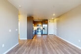 Located at 17607 East 61st Avenue in Denver, CO, this thoughtfully designed one-bedroom, one-bathroom residence offers a comfortable and modern living experience across a single floor. The open-concept layout seamlessly connects the living room, dining area, and kitchen, all finished with warm-toned luxury vinyl plank flooring that enhances the bright, airy atmosphere. A sliding glass door leads to a private balcony, allowing natural light to flood the main living space and providing pleasant outdoor views. The kitchen is a standout feature, showcasing rich wood-grain cabinetry extending to the ceiling, white quartz countertops, a herringbone tile backsplash with under-cabinet lighting, and a full suite of stainless steel appliances including a refrigerator with ice maker, range, microwave, and dishwasher. The spacious primary bedroom is carpeted for comfort and features a ceiling fan, dual windows with blinds, and access to a generously sized walk-in closet with wire shelving. The bathroom is finished with large-format tile flooring, a soaking tub with subway tile surround, and wood-grain cabinetry matching the kitchen. Additional conveniences include a dedicated laundry area, utility room, hallway, and two closets, rounding out this well-equipped residence.