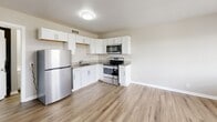 Located in Madison, TN, this 2-bedroom, 1-bathroom unit offers a practical and well-designed layout that maximizes its compact footprint. The open-concept main living area seamlessly connects the kitchen, dining, and living spaces, creating a bright and functional hub for daily living. Light wood-style flooring runs throughout the unit, lending a clean and cohesive aesthetic to every room.

The kitchen is a standout feature, equipped with stainless steel appliances including a refrigerator, electric range, and over-the-range microwave. White shaker-style cabinetry paired with granite countertops adds a modern touch, while the undermount sink completes the polished look.

Both bedrooms are finished with the same warm wood-style flooring and neutral gray walls. Each room benefits from natural light streaming through white-framed windows fitted with blinds, offering pleasant outdoor views. Two closets provide dedicated storage solutions for the bedrooms.

The bathroom is clean and functional, featuring a full tub-shower combo, a white vanity with a stone-look countertop, and wood-style flooring. A combined bathroom and laundry area, along with a dedicated utility room, adds everyday convenience. The unit's consistent neutral palette and modern finishes create a bright, move-in-ready living environment.