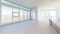 Located on the 43rd floor of Quayside Drive in New Westminster, BC, this generously sized 2-bedroom, 3-bathroom residence offers an elevated living experience with sweeping panoramic views of the Fraser River and surrounding cityscape. Floor-to-ceiling windows flood the open-concept living, dining, and kitchen area with abundant natural light, highlighting the light-toned hardwood flooring and clean, modern finishes throughout. The spacious primary bedroom is well-appointed and benefits from the same dramatic views, complemented by ample closet space. A versatile den provides additional flexibility for a home office or guest space. Three beautifully finished bathrooms feature floating wood vanities with stone countertops, backlit mirrors, large-format marble-style tiles, and glass-enclosed showers, reflecting a refined contemporary aesthetic. A dedicated laundry room and pantry add everyday practicality. The private balcony, framed by glass railings and floor-to-ceiling glazing, extends the living space outdoors with breathtaking elevated views of the mountains and river. Throughout, the residence maintains a crisp, modern palette of whites and natural wood tones, creating a bright and sophisticated atmosphere.