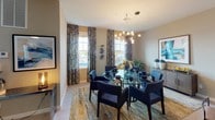This two-story residence in Bayonne, NJ offers a thoughtfully designed layout across three bedrooms and three full bathrooms, providing ample space for comfortable everyday living. The main level features an open-concept flow connecting the living, dining, and kitchen areas. The living room is finished with light wood-look tile flooring, neutral wall tones, and a large window with patterned drapery that brings in natural light. The adjacent dining area accommodates a full-sized table beneath a contemporary globe chandelier, with dual windows enhancing the brightness of the space.

The kitchen is a functional centerpiece, outfitted with rich dark cabinetry, granite countertops, subway tile backsplash, and a full suite of stainless steel appliances including a gas range, built-in microwave, dishwasher, and refrigerator.

The primary bedroom upstairs features vaulted ceilings, plush carpeting, soft blue-gray walls, and a window that admits natural light. Its en-suite bathroom includes a double-sink vanity with granite countertops, dark cabinetry, and a glass-enclosed shower. Additional bedrooms offer comfortable proportions with carpeted floors and cool-toned walls. The bathrooms throughout maintain a consistent design language with granite counters and dark wood vanities.