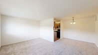 Located at 500 Chews Landing Rd in Lindenwold, NJ, this one-bedroom, one-bathroom unit offers a well-organized, single-floor layout designed for comfortable everyday living. The combined living room and kitchen area forms the heart of the home, with the living space featuring soft carpeting, neutral cream-toned walls, and a large multi-pane window that allows generous natural light to fill the room. A private entry door opens directly into this welcoming area. The galley-style kitchen is efficiently designed with warm wood cabinetry, granite-look countertops, a stainless sink, and black appliances including a range and refrigerator, all set atop durable wood-look flooring. The bedroom is a well-proportioned retreat, brightened by a window with outdoor views and featuring plush carpeting underfoot. A standout feature of the bedroom is the dual set of full-length bifold closets, providing exceptional storage space. The bathroom is clean and functional, finished with rich wood-toned cabinetry, a wide vanity with a light countertop, stone-look tile flooring, and a full tub-shower combination. Throughout the unit, the consistent use of neutral tones and practical finishes creates a cohesive, move-in-ready atmosphere.