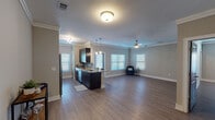 This single-story, 2-bedroom, 2-bathroom residence offers a thoughtfully designed open-concept floor plan that seamlessly connects the kitchen and living areas. The interior is finished with durable wood-look flooring throughout, complemented by crown molding and neutral gray walls that create a clean, cohesive aesthetic.

The kitchen is a standout feature, showcasing dark espresso cabinetry, granite countertops, a subway tile backsplash, stainless steel appliances including a refrigerator, range, microwave, and dishwasher, and a built-in wine rack above the refrigerator. A peninsula with a stainless steel sink provides additional prep space and opens directly to the living area, which is brightened by multiple windows with white blinds and outfitted with a ceiling fan.

Both bedrooms are comfortably sized, featuring wood-look flooring, crown molding, ceiling fans, and windows that allow natural light. The primary bedroom includes a walk-in closet equipped with wire shelving and multiple hanging rods for ample storage.

The bathrooms mirror the kitchen's design language, featuring dark vanity cabinetry, granite countertops, large framed mirrors, and wood-look flooring. The overall ambiance is modern and functional, with consistent finishes tying every room together cohesively.