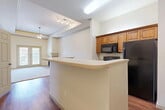 This well-designed apartment offers a comfortable living experience within its 890 square feet of space. The open-concept living area is highlighted by a corner fireplace, creating a warm focal point. Large windows provide ample natural light, while ceiling fans ensure good air circulation. The kitchen boasts wood cabinetry, black appliances, and a practical layout with ample counter space. Both bedrooms are generously sized, with the primary bedroom measuring 170 square feet. Each bedroom features plush carpeting and sizable closets for storage. The two bathrooms are finished with tile flooring and modern fixtures, including a combination tub-shower. Throughout the apartment, neutral tones create a versatile backdrop for various decor styles. Additional features include built-in shelving in one of the rooms, providing extra storage or display space. The apartment's layout efficiently utilizes the available space, creating a balanced and functional living environment suitable for various lifestyle needs.