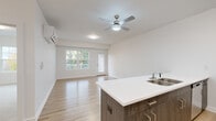 Located at 255 Cemetery Rd in Troy, NY, this thoughtfully designed 2-bedroom, 1-bathroom home offers a clean, modern aesthetic throughout its single-floor layout. The open-concept living and kitchen area serves as the heart of the home, featuring light hardwood-style flooring, crisp white walls, and a ceiling fan with integrated lighting. A wall-mounted mini-split unit provides efficient climate control. Sliding glass doors and large windows flood the space with natural light and lead to an outdoor deck overlooking a lush, wooded backdrop.

The kitchen is outfitted with warm wood-toned cabinetry, a white quartz peninsula with an undermount sink, and a full suite of stainless steel appliances, including a range, microwave, and refrigerator. The spacious primary bedroom features hardwood-style flooring, a wall-mounted HVAC unit, and a large window with outdoor views, while a dedicated walk-in closet provides ample built-in wire shelving for storage. The second bedroom is carpeted and comfortably sized with its own window and closet access. The full bathroom includes a tub/shower combination, a vanity with cabinetry, and light wood-tone flooring, completing this well-appointed home.