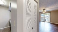 Located in West Lafayette, Indiana, this single-floor, 2-bedroom, 2-bathroom unit offers a practical and well-organized layout. The living room serves as the centerpiece of the space, featuring durable hardwood-style flooring, a ceiling fan with light fixture, and a sliding glass door that opens to a private balcony, filling the room with natural light and outdoor views.

The galley-style kitchen flows directly from the living area and is equipped with dark espresso cabinetry, granite-style countertops, black appliances including a refrigerator, electric range, microwave, and dishwasher, as well as a double-basin stainless steel sink. Wood-look flooring continues throughout the kitchen and hallway.

Both bedrooms are carpeted and feature neutral wall tones, textured ceilings, and dedicated walk-in closets with built-in shelving and hanging rods. The primary bedroom offers a comfortable, functional footprint. Each bedroom is served by its own full bathroom, both featuring tiled tub-shower combinations, wood-look flooring, and vanities with ample cabinet storage.

A hallway with a louvered storage closet connects the main living areas to the bedrooms, contributing to the unit's efficient and cohesive layout.