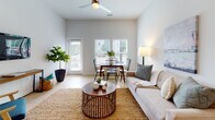 Located at 260 Pidgeon Bay Rd in Summerville, SC, this thoughtfully designed single-floor residence offers a clean, contemporary aesthetic throughout. The kitchen is a standout feature, outfitted with crisp white shaker cabinetry extending to the ceiling, grey quartz-style countertops, and a full suite of stainless steel appliances including a French door refrigerator, electric range, over-the-range microwave, and dishwasher. Light hardwood-style flooring runs through the main living areas, adding warmth and continuity. The open living and dining area is bright and welcoming, with elevated ceilings, a ceiling fan, and large windows that invite natural light and provide views of the surrounding greenery. A private entry door opens directly into this space. The bedroom is generously sized with plush carpet flooring, multiple windows, and a spacious reach-in closet with built-in rod storage. Two full bathrooms serve the unit — one featuring a shower/tub combo and wood-look flooring, and the other offering a wide vanity with ample cabinet storage. A dedicated laundry area houses a full-size Whirlpool washer and dryer with overhead shelving, adding everyday convenience to this well-rounded home.