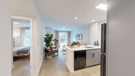 Located at 1 Hawaii Ave NW in Washington, DC, this one-bedroom, one-bathroom residence offers a thoughtfully laid-out floor plan that maximizes its compact footprint. Light-toned hardwood flooring flows throughout, creating a cohesive and airy aesthetic across every room.

The open-concept kitchen and living area serves as the heart of the home. The kitchen is outfitted with gray shaker-style cabinetry, stainless steel and black appliances, and a generous white quartz peninsula with seating for multiple guests — ideal for casual dining or entertaining. Recessed and linear lighting illuminates the workspace efficiently. The adjacent living room benefits from a large picture window that frames views of the neighborhood streetscape, filling the space with natural light.

The bedroom is a calm and comfortable retreat, featuring a sizable window overlooking greenery, light walls, and warm wood flooring that carries through from the main living area. The room comfortably accommodates a full-sized bed and additional furnishings.

The bathroom is finished with clean white subway tile in the shower-tub combo, a sleek gray vanity with a white countertop, black hardware accents, and modern tile flooring, delivering a polished, contemporary look. A hallway connects the rooms, adding privacy and a natural flow to the overall layout.