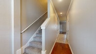 Located on Arborside Rd in Tontitown, Arkansas, this two-story home offers a well-designed layout with a thoughtful mix of finishes across both levels. The main living area showcases rich hardwood flooring, crown molding, and a ceiling fan, creating a warm and inviting atmosphere with natural light filtering through blinds-covered windows.

The kitchen is a standout feature, outfitted with crisp white shaker-style cabinetry extending to the ceiling, granite countertops, a central island for additional prep space, and a full suite of stainless steel appliances including a refrigerator, electric range, microwave, and dishwasher. Light tile flooring and recessed lighting with pendant accents complete the space.

Bedrooms are carpeted for comfort and each includes a ceiling fan. The primary bedroom is generously sized, featuring dual walk-in closets and direct access to additional rooms. Secondary bedrooms are well-proportioned with windows offering natural light.

Bathrooms are finished with warm tile flooring and include full tub-shower combinations with brushed nickel fixtures. The staircase, lined with carpet and white railings, connects the two floors via a hallway with tile and hardwood flooring. This home presents a clean, functional design suited for comfortable everyday living.