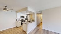 Located in Ontario, California, this 2-bedroom, 1-bathroom residence offers a thoughtfully designed layout with modern finishes throughout. The open-concept kitchen and living area serves as the heart of the home, featuring white shaker cabinetry, stainless steel appliances including a range, microwave, and refrigerator, gray quartz countertops, and a peninsula with a sink that seamlessly connects to the living space. Light wood-style flooring runs throughout the main living areas, enhancing the bright and airy ambiance.

The living room is generously proportioned and opens directly to a private balcony through sliding glass doors, bringing in natural light and outdoor views. Both bedrooms are carpeted for comfort; the primary bedroom includes dual closets with wire shelving, offering ample storage. A well-sized window in the secondary bedroom allows for natural light.

The bathroom is clean and functional, appointed with white cabinetry, gray quartz countertops, a large vanity mirror, and a shower-tub combination. A dedicated in-unit laundry area houses a full-size side-by-side washer and dryer. A hallway connects all rooms, contributing to an efficient and practical floor plan throughout the residence.