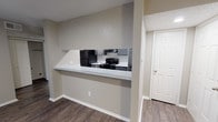 Located at 7662 Courtney Oaks Dr in Fort Worth, TX, this single-story unit offers a well-designed, functional layout with a cohesive modern aesthetic throughout. Dark hardwood-style flooring runs consistently across the living areas, bedrooms, and kitchen, providing a warm and unified feel.

The kitchen is efficiently arranged in a galley style, featuring gray cabinetry, light speckled countertops, black appliances including a refrigerator and electric range, and a classic white subway tile backsplash. A pass-through counter connects the kitchen to the adjacent dining area, creating an open sightline and casual serving space.

The living room is a welcoming area highlighted by a white-mantled fireplace, a ceiling fan with light fixture, and a textured ceiling. Natural light filters in through a window with blinds, adding brightness to the neutral gray walls.

The bedrooms are comfortably sized, each equipped with ceiling fans and windows that allow ample natural light. One bedroom features a walk-in closet and vertical blinds, offering added storage and privacy. The bathroom includes a full tub-shower combination with white tile surround, dark vanity with light countertop, and brushed nickel fixtures and hardware. Textured ceilings are present throughout, adding a classic residential character to the space.