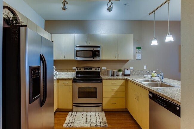 Open kitchen features beautiful granite countertops with six inch granite backsplash and luxury vinyl plank flooring - The Matisse