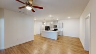 Located at 4663 Joor Rd in Baton Rouge, Louisiana, this single-story, 3-bedroom, 2-bathroom home offers a clean, modern aesthetic throughout its well-designed floor plan. The open-concept living and kitchen area serves as the heart of the home, featuring warm wood-look luxury vinyl plank flooring, recessed lighting, and a ceiling fan in the living room. The kitchen is a standout, showcasing gray shaker-style cabinetry, a marble-look quartz center island with an undermount sink, pendant lighting, and black appliances including a refrigerator, range, and microwave. A hallway connects the common areas to the private quarters, where three bedrooms are finished with plush carpet and ceiling fans. The generously sized primary bedroom offers comfortable proportions and is complemented by a well-appointed bathroom featuring a dual-sink vanity with gray cabinetry. The second bathroom includes a tub-shower combo, a gray vanity, and wood-look flooring. Closets with built-in shelving and hanging rods provide practical storage. Throughout, the home maintains a bright, neutral color palette with white walls and clean trim, creating a fresh and move-in-ready atmosphere.