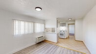 Located at 300 E Foothill Blvd in Pomona, CA, this one-bedroom, one-bathroom unit offers a practical and well-organized layout across a single floor. The bedroom features warm hardwood-style flooring, clean white walls, and a window fitted with vertical blinds that allows natural light to filter in. A flush-mount ceiling light provides additional illumination, and a dedicated walk-in closet with built-in shelving and a hanging rod offers ample storage. The kitchen is thoughtfully appointed with gray shaker-style cabinetry, granite-look countertops, a double-basin sink, a white gas range with overhead ventilation, and a full-size refrigerator. Light ceramic tile flooring runs through the kitchen, and open shelving provides extra storage space. The bathroom includes a tiled shower-tub combo, toilet, and matching tile flooring, maintaining a clean and functional aesthetic. Neutral white walls are consistent throughout the unit, contributing to a bright and cohesive atmosphere. The overall layout is efficient and well-suited for single occupancy, with each room serving a clear purpose and all essential amenities in place.