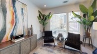 Located in the heart of Uptown Charlotte at 558 E Stonewall St, this thoughtfully designed single-floor residence combines contemporary style with functional living. The open-concept layout features wood-look flooring throughout the main living areas, connecting the kitchen, dining, and living spaces seamlessly. The kitchen is a standout, outfitted with custom grey shaker cabinetry extending to the ceiling, stainless steel appliances including a French door refrigerator, a white subway tile backsplash, and a built-in wine rack — offering ample storage and a refined aesthetic. The living area is bright and welcoming, with large windows framing views of the Charlotte skyline and allowing generous natural light to fill the space. Multiple bedrooms offer plush carpeting, ceiling fans, and large windows, providing comfortable and versatile retreats. The primary bathroom features a dual-sink vanity with white countertops, a glass-enclosed shower, and a walk-in closet, while a second full bathroom includes both a soaking tub and a separate glass shower. A well-organized entry hallway with multiple grey panel doors provides convenient closet access. Throughout the residence, clean white walls, recessed lighting, and a cohesive grey-and-neutral palette create a modern, polished ambiance ideal for urban living.