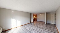 Located at 2701 38th St NW in Canton, Ohio, this two-bedroom, one-bathroom unit offers a well-organized single-floor layout with a thoughtful mix of spaces. The living room is bright and open, featuring light-toned luxury vinyl plank flooring, neutral walls, and a textured ceiling. Sliding glass doors lead directly to a private balcony, allowing natural light to pour into the room. The adjacent dining area flows naturally into the kitchen, which is equipped with warm wood-toned cabinetry and a ceiling fan overhead. The kitchen features a peninsula-style counter, tile backsplash accents, and ample cabinet storage. Both bedrooms are carpeted and include ceiling fans with light fixtures. The primary bedroom offers a comfortable footprint with access to closet space, while the second bedroom features sliding wood-panel closet doors and a window with blinds for natural light. Four closets throughout the unit provide generous storage options. The full bathroom includes a tub-shower combination, a wood-vanity with an integrated sink, a large mirror, and tile-accented walls. A utility room and dedicated hallway complete the layout, adding practicality to the overall design of this functional Canton residence.