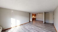 Located at 2701 38th St NW in Canton, Ohio, this two-bedroom, one-bathroom unit offers a well-organized single-floor layout with a thoughtful mix of spaces. The living room is bright and open, featuring light-toned luxury vinyl plank flooring, neutral walls, and a textured ceiling. Sliding glass doors lead directly to a private balcony, allowing natural light to pour into the room. The adjacent dining area flows naturally into the kitchen, which is equipped with warm wood-toned cabinetry and a ceiling fan overhead. The kitchen features a peninsula-style counter, tile backsplash accents, and ample cabinet storage. Both bedrooms are carpeted and include ceiling fans with light fixtures. The primary bedroom offers a comfortable footprint with access to closet space, while the second bedroom features sliding wood-panel closet doors and a window with blinds for natural light. Four closets throughout the unit provide generous storage options. The full bathroom includes a tub-shower combination, a wood-vanity with an integrated sink, a large mirror, and tile-accented walls. A utility room and dedicated hallway complete the layout, adding practicality to the overall design of this functional Canton residence.