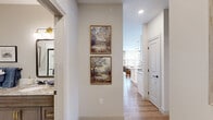 Located at 3411 Trabue Rd in Columbus, Ohio, this thoughtfully designed single-floor residence offers two bedrooms, two bathrooms, a living room, and a well-equipped kitchen, all connected by a central hallway with dedicated closet storage. The kitchen is a standout feature, showcasing crisp white shaker cabinetry with brass hardware, granite countertops, stainless steel appliances, a subway tile backsplash, and a generous island with seating — all illuminated by a statement glass pendant light and warm recessed lighting. Light hardwood flooring flows throughout the main living areas, enhancing the bright, airy atmosphere. The living room is bathed in natural light from large windows dressed with decorative drapes, creating an inviting and comfortable gathering space. The primary bedroom is a well-proportioned retreat featuring large windows, wall sconces, and elegant paneling details. The second bedroom mirrors the same warmth with ample natural light and tasteful finishes. Both bathrooms are finished with granite-topped vanities and dark wood cabinetry; one features a dual-sink vanity with framed mirrors and globe lighting, while the other offers marble-look tile flooring and classic wainscoting. The overall ambiance is polished, warm, and move-in ready.