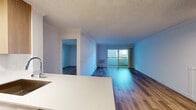 This 890 square foot apartment in Newport Beach offers a harmonious blend of comfort and modern design. The single-floor layout comprises one bedroom, one bathroom, and an open-concept living area. The primary bedroom, measuring 250 square feet, provides ample space for relaxation.

The interior is characterized by sleek, contemporary finishes. Gleaming hardwood floors run throughout, varying from warm honey tones to cooler, multi-toned planks that add visual interest. The walls are painted in crisp white, creating a bright, airy atmosphere enhanced by the abundance of natural light streaming through large windows.

The kitchen is a standout feature, boasting light wood cabinetry, stainless steel appliances, and a pristine white countertop with a modern sink. The open layout seamlessly connects the kitchen to the living area, ideal for entertaining or casual dining.

The bathroom, while compact, is efficiently designed with a bathtub-shower combination and clean, white fixtures. A private balcony offers outdoor space, perfect for enjoying the California climate.

Located in the Eight 80 Newport Beach complex, this apartment combines modern living with the allure of a coveted coastal location, making it an attractive option for those seeking a contemporary lifestyle in a desirable area.