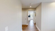 Located at 95 Cedar St in Providence, Rhode Island, this single-floor, three-bedroom, two-bathroom home offers a well-designed layout with a consistent modern aesthetic throughout. Wood-style flooring runs seamlessly across every room, complemented by neutral warm-gray walls, crisp white trim, and recessed lighting that keeps the interior bright and welcoming.

The spacious primary bedroom is generously sized, featuring dual windows fitted with white horizontal blinds that allow natural light to filter in while offering views of the surrounding neighborhood. A double sliding closet provides ample storage, and recessed ceiling lights complete the clean, functional design. The two additional bedrooms maintain the same finishes, each with windows that invite natural light and easy access to the hallway.

Both bathrooms are finished to a high standard. One features a sleek walk-in glass shower with chrome fixtures and a white vanity topped with a backlit mirror, while the second bathroom offers a vanity with a crisp white countertop and a matching illuminated mirror. Wood-style flooring carries through both bathrooms, maintaining the home's cohesive design language.

A connecting hallway links the rooms efficiently, reinforcing the practical and open flow of the floor plan. Overall, this home presents a clean, modern, and move-in-ready living environment.