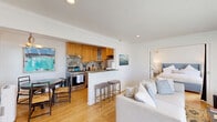 This 540 square foot apartment in Santa Monica offers a well-designed living space that maximizes functionality. The single-floor layout comprises a bedroom, living room, kitchen, and bathroom. The living area is bathed in natural light, thanks to large sliding glass doors that lead to an outdoor space. Hardwood floors run throughout, lending warmth and continuity to the space.

The bedroom, measuring 210 square feet, features a comfortable bed with a blue upholstered headboard and ample storage solutions. The bathroom, while compact, is efficiently designed with a pedestal sink, toilet, and shower/tub combination. White cabinetry and light blue walls create a clean, fresh aesthetic.

The kitchen, though small, is well-equipped with wooden cabinetry, granite countertops, and stainless steel appliances. A decorative tile backsplash adds visual interest. The living room doubles as a dining area, with space for a small table and chairs. Thoughtful touches like a modern entertainment center, stylish light fixtures, and carefully chosen artwork contribute to the apartment's overall appeal.

Located at 2101 Ocean Ave, this apartment offers the perfect blend of comfort and convenience in the heart of Santa Monica. Its efficient use of space and proximity to local amenities make it an ideal home for those seeking a cozy urban dwelling.