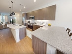 This contemporary residence in McKinney, Texas, offers 1560 square feet of thoughtfully designed living space across two floors. The home boasts three bedrooms, including a generous 180-square-foot primary suite, and four full bathrooms for ultimate convenience.

The heart of the home is a sleek, open-concept kitchen featuring modern wood cabinetry, stainless steel appliances, and a large center island with a undermount sink. Granite countertops and stylish pendant lighting add a touch of elegance. The adjacent living area provides ample space for relaxation and entertainment.

Each bedroom is well-appointed with large windows allowing natural light to flood the spaces. Ceiling fans ensure comfort year-round. The bathrooms showcase contemporary design with glass-enclosed showers, modern fixtures, and spacious vanities.

The home's practical amenities include a dedicated laundry room with front-loading washer and dryer, complemented by overhead cabinetry for storage. Throughout the house, a mix of warm wood-look flooring and plush carpeting creates a cohesive and inviting atmosphere.

The property's layout efficiently utilizes space with well-placed hallways and closets for storage. Windows with horizontal blinds are featured throughout, offering privacy and light control. The overall design embraces a clean, minimalist aesthetic with crisp white walls, creating a bright and airy feel in every room.

Located on Canopy Drive, this home combines modern comfort with practical living, making it an ideal residence in the desirable McKinney area.