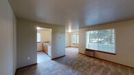 Located at 911 E Beacon Ave in Spokane, WA, this one-bedroom, one-bathroom unit offers a well-organized, single-floor layout that makes efficient use of its living space. The kitchen is a standout feature, equipped with warm honey-toned wood cabinetry, a tile backsplash, white appliances including a refrigerator, electric range, microwave, and dishwasher, and durable tile flooring. A wraparound breakfast bar separates the kitchen from the living area, creating an open and connected feel throughout the main living space. Neutral-toned carpet flows through the living area and into the bedroom, lending a cohesive and comfortable atmosphere. The bedroom is generously sized, featuring a wide window that invites natural light and frames views of the surrounding greenery. A sliding double-door closet provides ample storage, with additional doors leading to the hallway and utility areas. The bathroom is clean and functional, offering a full-size soaking tub with a shower and chrome fixtures, accompanied by a vanity with tile accents and a mirrored wall. Textured ceilings and warm wood-toned trim and doors are consistent throughout, giving the unit a unified, well-maintained character. This unit is practical, comfortable, and ideally suited for those seeking straightforward, functional living in Spokane.