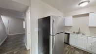 Located at 841 Gawain Cir in Dayton, Ohio, this two-story home offers a well-organized layout with thoughtfully updated interiors throughout. The kitchen is a functional highlight, outfitted with white shaker-style cabinetry, light granite-look countertops, a stainless steel refrigerator and dishwasher, a black electric range with overhead ventilation, and a single-basin sink — all set atop durable wood-look plank flooring that carries through the main living areas. The open living space benefits from natural light and connects seamlessly to adjoining rooms, creating an easy flow across the floor plan. A staircase leads to the upper level, where carpeted bedrooms provide a softer, quieter atmosphere. Multiple bedrooms feature windows that invite natural light, and at least one bedroom includes dual closets with built-in rods, offering generous storage capacity. The bathroom is clean and efficiently designed, featuring a white vanity with brushed nickel hardware, a tub-shower combination, and matching wood-look flooring. Textured ceilings and neutral wall tones are consistent throughout, lending a cohesive and move-in-ready feel to the entire home.