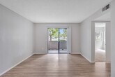Located at 650 Ebbcreek Drive in Corona, California, this 2-bedroom, 2-bathroom single-floor home offers a clean, modern aesthetic throughout. The thoughtfully designed kitchen is a standout feature, showcasing white shaker-style upper cabinets, grey lower cabinets, quartz countertops, and a full suite of stainless steel appliances including an electric range, dishwasher, and refrigerator. Light wood-style flooring runs through the kitchen and living areas, adding warmth and continuity. The living room is bright and open, with a sliding glass door that invites natural light and provides access to outdoor views. A connecting hallway leads to both bedrooms, each finished with plush carpeting and sliding closet doors. The spacious primary bedroom features dual corner windows that frame greenery outside. Both bathrooms are well-appointed, with one offering a tub-shower combo and the other featuring quartz countertops, an undermount sink, and backlit mirrors. Neutral grey tones and textured ceilings are consistent throughout, creating a cohesive and move-in-ready living environment.