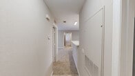 Located in Gainesville, FL, this single-floor, 2-bedroom, 2-bathroom unit offers a practical and well-organized layout designed for comfortable everyday living. The kitchen features warm honey-toned cabinetry, white appliances including a refrigerator and electric range, light tile flooring, and a breakfast bar peninsula that opens to the adjacent living area, creating an efficient and connected space. Overhead fluorescent lighting ensures the kitchen remains bright and functional. The two bedrooms are carpeted in neutral tones and bathed in natural light from double windows fitted with blinds, offering a calm and restful atmosphere. The generously sized primary bedroom provides ample space, while the second bedroom mirrors a similar design aesthetic. Both bathrooms are finished with light tile flooring, warm wood vanity cabinetry, white countertops, and full tub-shower combinations, maintaining a clean and consistent style throughout. Neutral beige walls flow throughout the unit, creating a cohesive and understated palette. A hallway connects the main rooms, and a dedicated utility room adds practical storage and laundry capabilities. The overall design prioritizes functionality and ease of living in a straightforward, well-maintained floor plan.