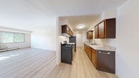Located at 1674 Shawano Ave in Green Bay, Wisconsin, this one-bedroom, one-bathroom unit offers a well-organized and functional single-floor layout. Light wood-tone flooring runs throughout the main living areas, creating a clean, cohesive aesthetic.

The galley-style kitchen is efficiently designed with warm-toned wood cabinetry on both sides, granite-look countertops, a stainless steel sink, a gas range with overhead ventilation, a dishwasher, and a full-size refrigerator — providing ample workspace and storage for everyday cooking. The kitchen opens directly into a combined dining and living area, offering a connected, open feel. The family room is generously proportioned, bathed in natural light through a large multi-pane window with views of mature trees, and features baseboard heating and a wall-mounted A/C unit.

The bedroom is a comfortable retreat, finished with soft carpeting, a window overlooking the outdoors, baseboard heating, and a wide double-door closet providing substantial storage. A hallway connects the living spaces to the full bathroom, which features a white-tiled tub-shower combination, a vanity, and light wood-tone flooring. Two closets throughout the unit offer additional organizational convenience.