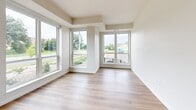 Located at 4021 Coon Rapids Blvd NW in Coon Rapids, Minnesota, this one-bedroom, one-bathroom unit offers a well-designed, single-floor layout that makes efficient use of its space. The open-concept kitchen and living area serves as the heart of the unit, featuring light hardwood flooring, recessed lighting, and an abundance of natural light from large windows that offer outdoor views of the surrounding neighborhood. The kitchen is outfitted with white shaker-style cabinetry, granite countertops, a white subway tile backsplash, and a full suite of stainless steel appliances including a refrigerator, electric range, microwave, and dishwasher. A bright hallway with recessed lighting and clean white walls connects the main living area to the private spaces, including a dedicated closet for storage. The bedroom is carpeted for comfort and features a large window that brings in natural light and outdoor views. The full bathroom includes a tub/shower combination and hardwood-style flooring. An in-unit laundry area adds everyday convenience. The unit's modern, neutral palette and clean architectural lines create a bright, cohesive ambiance throughout.